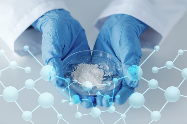 Person with gloves holding powder in a petri dish