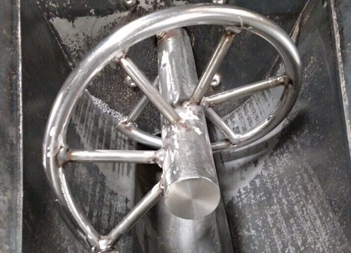 Round bar agitator for flexible screw conveyor
