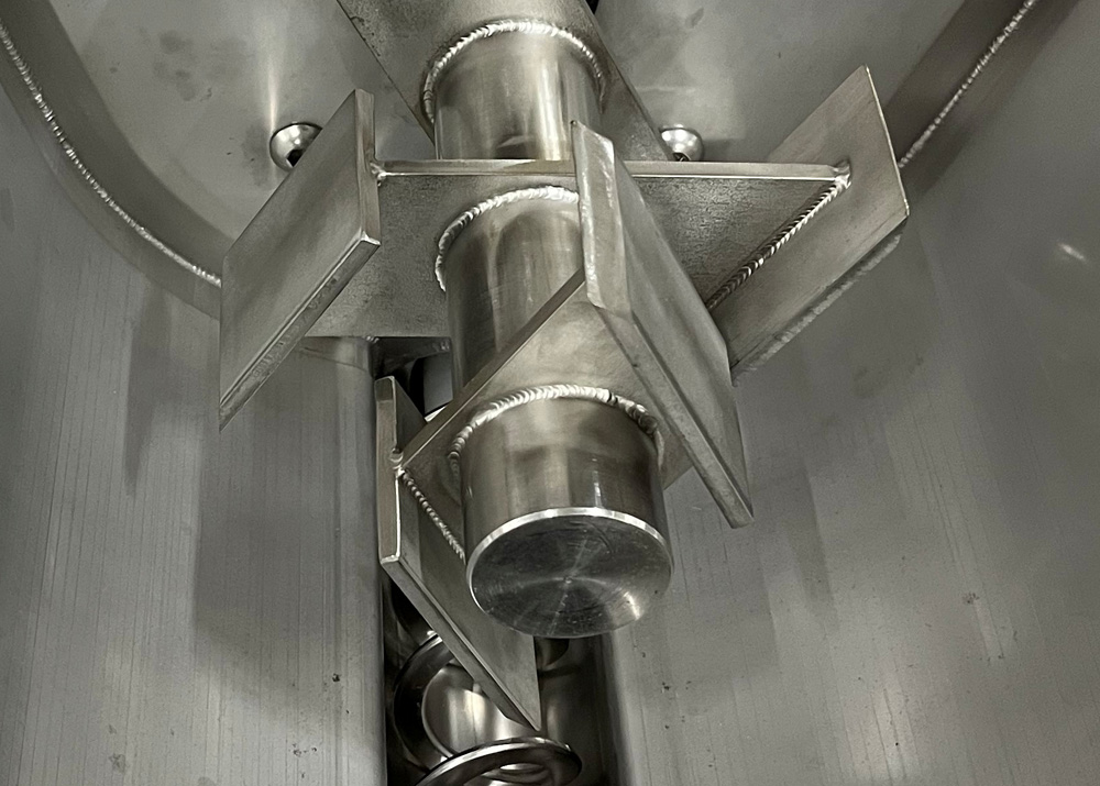Rotary blade hopper agitator for flexible screw conveyor