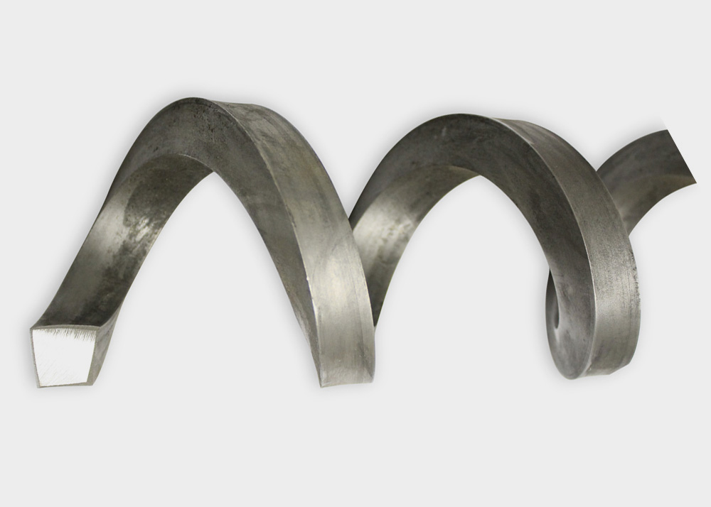 A metal auger flight with a spiral shape.
