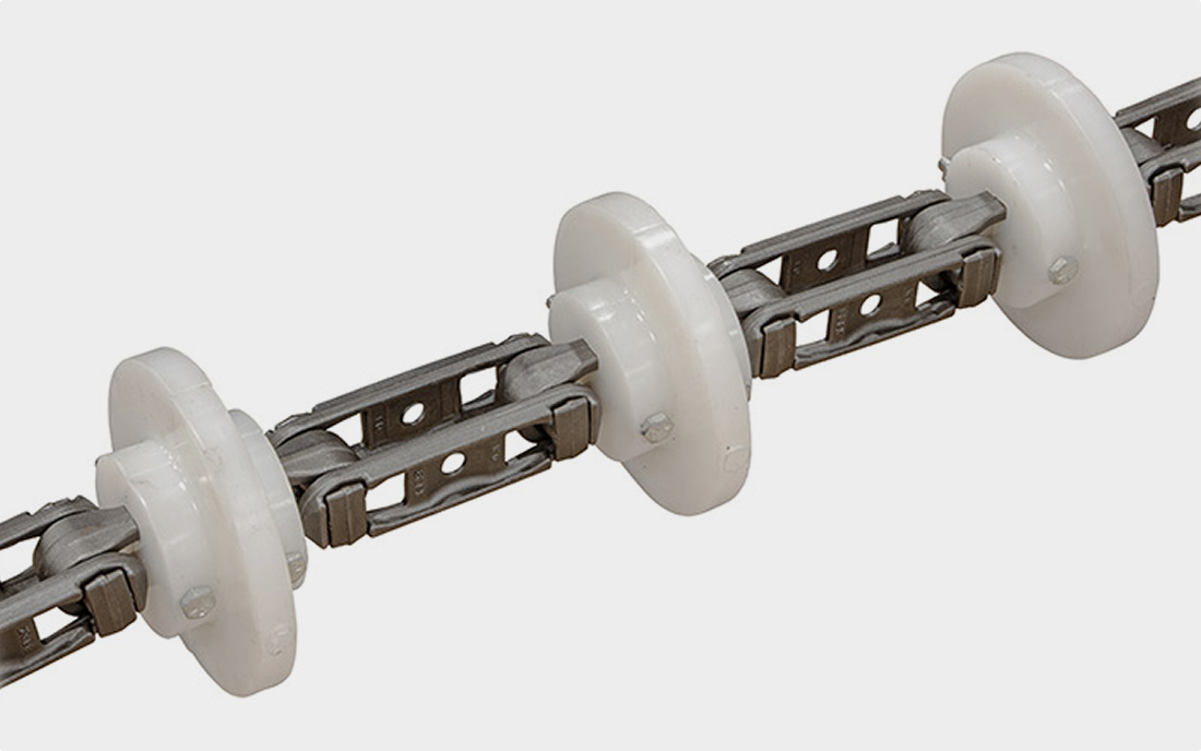 A metal industrial chain featuring evenly spaced white plastic rollers.