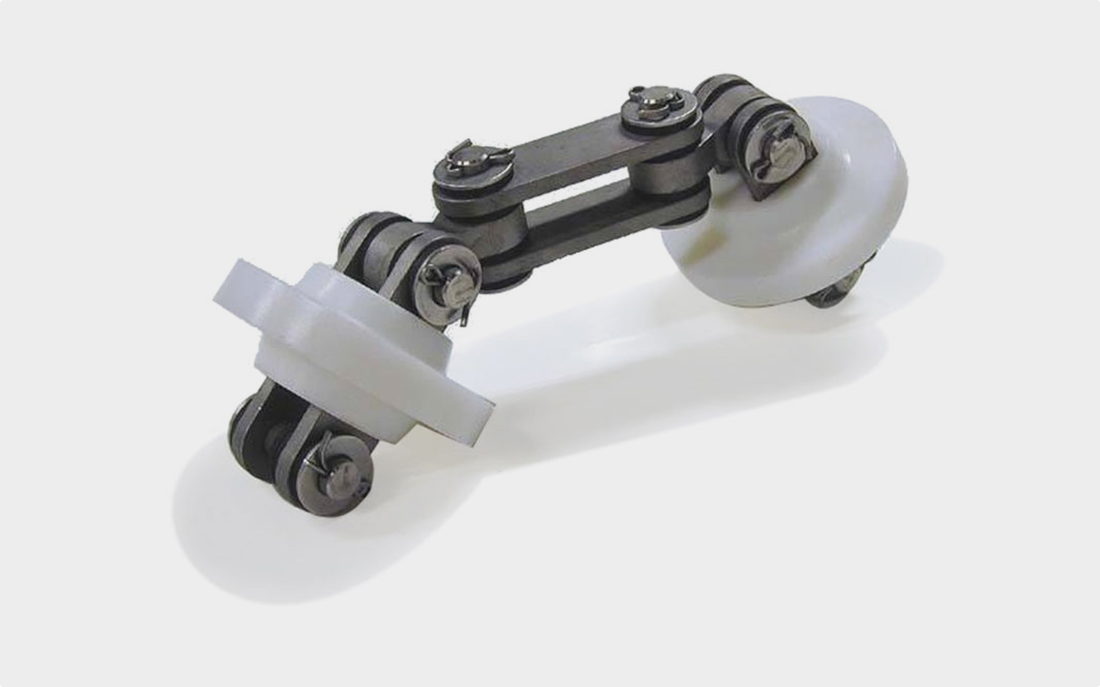 A metal roller chain assembly with two white plastic guide wheels.